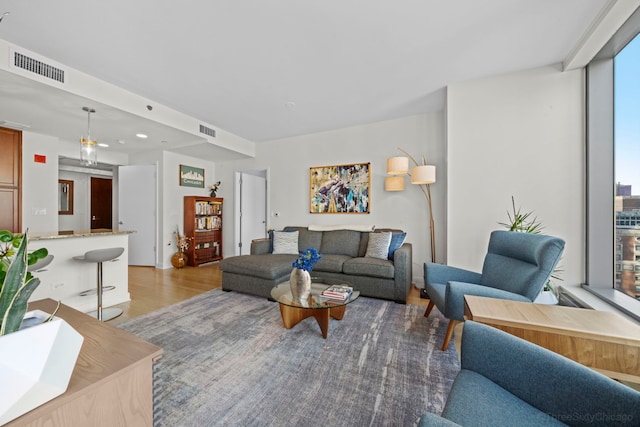 living area with light wood-type flooring and visible vents