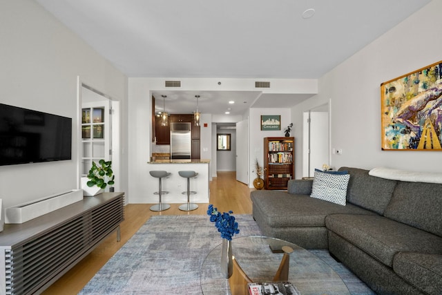 living room with light wood-style floors and visible vents