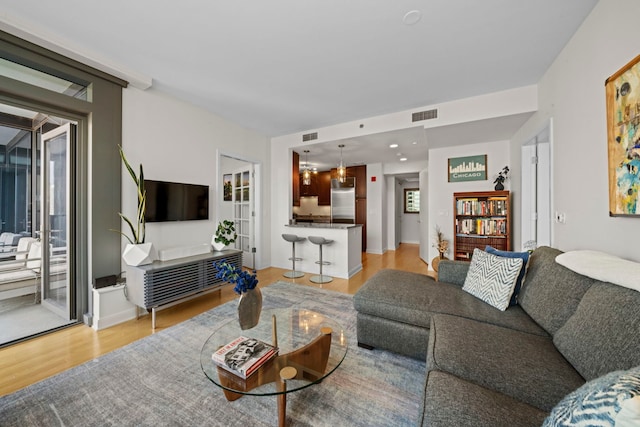 living room featuring visible vents and light wood finished floors