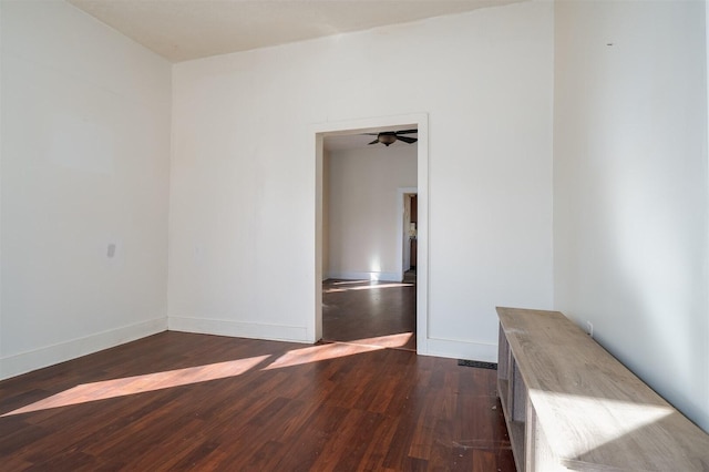 empty room featuring dark wood-style floors and baseboards