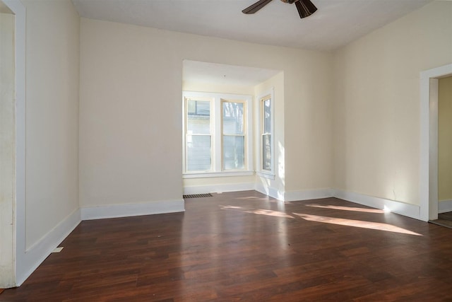 empty room with ceiling fan, wood finished floors, and baseboards