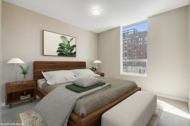 bedroom with baseboards, a city view, and carpet flooring