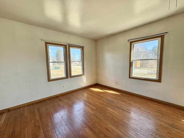 empty room with baseboards and hardwood / wood-style floors