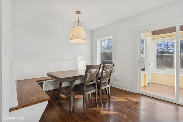 dining space featuring wood finished floors and baseboards