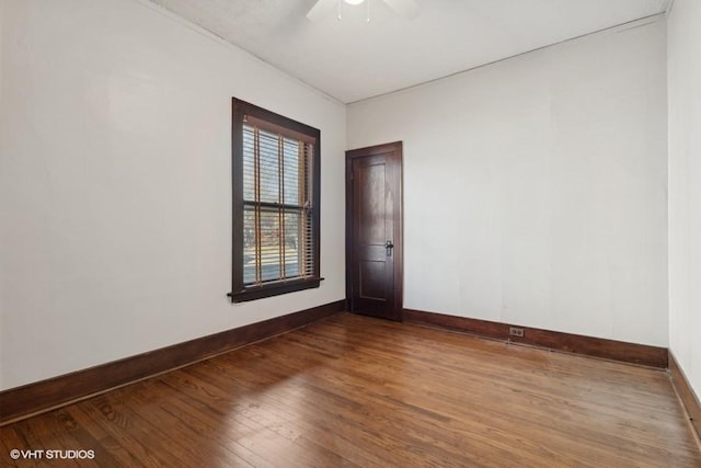 spare room featuring wood finished floors and baseboards