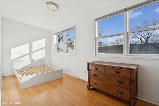 unfurnished bedroom featuring wood finished floors and baseboards