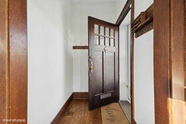 entryway with baseboards and wood finished floors