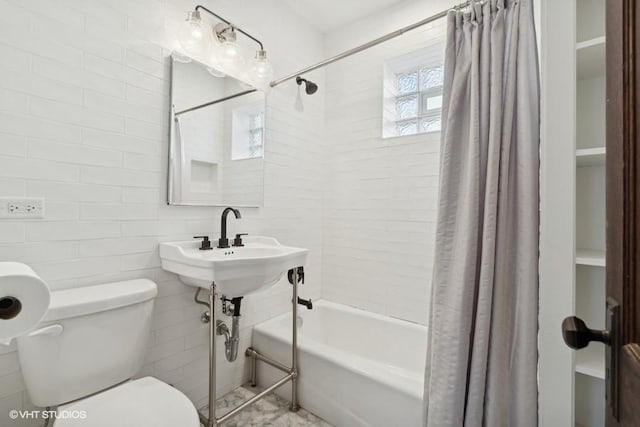 full bathroom featuring shower / tub combo, tile walls, and toilet