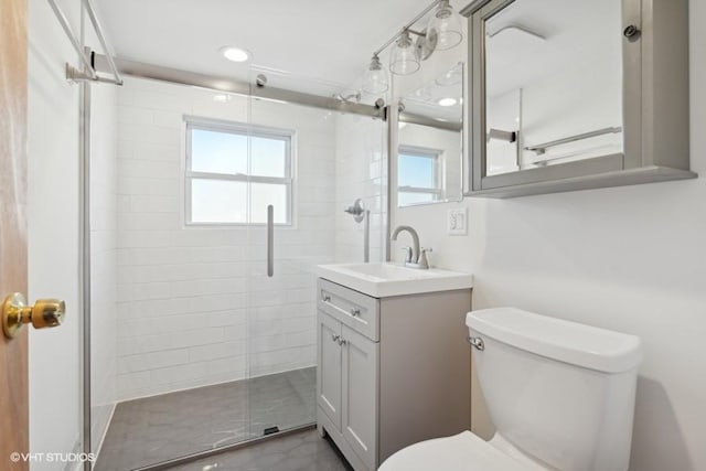 full bath featuring a stall shower, vanity, toilet, and recessed lighting