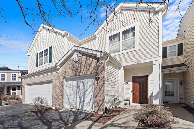 view of front of property featuring a garage and aphalt driveway