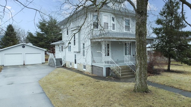 view of front of house with a porch, a front yard, an outdoor structure, and a detached garage