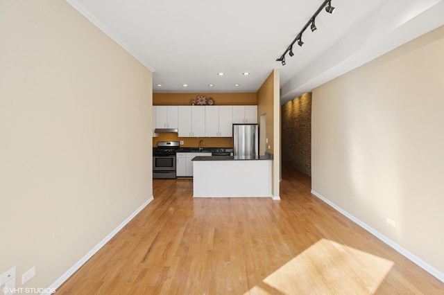 kitchen with stainless steel appliances, dark countertops, white cabinets, under cabinet range hood, and baseboards