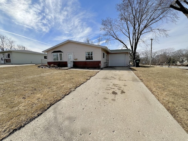 view of front of house featuring a garage, a front yard, brick siding, and driveway