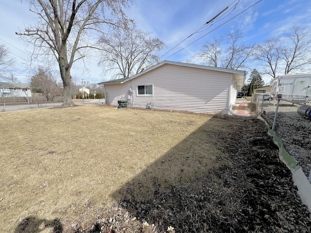 back of house featuring a lawn and fence