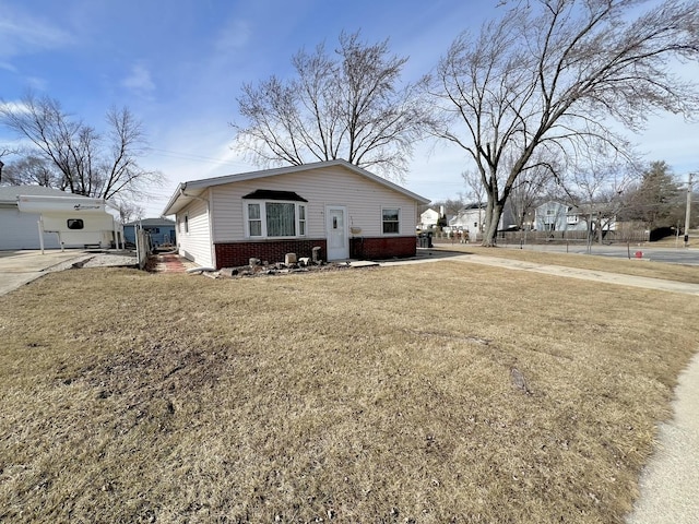 view of property exterior featuring driveway, brick siding, and a lawn