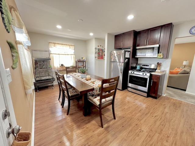 kitchen featuring stainless steel appliances, recessed lighting, dark brown cabinetry, and light wood-style flooring