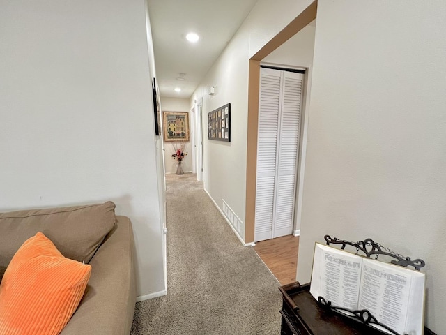 hallway featuring carpet floors and baseboards