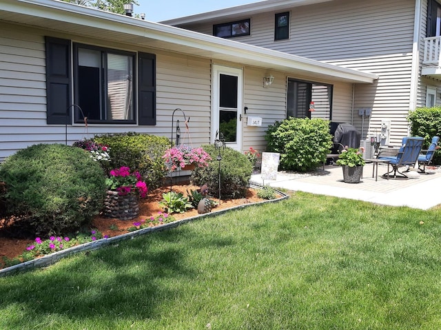 property entrance featuring a patio and a lawn