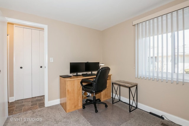 office space featuring stone finish flooring and baseboards