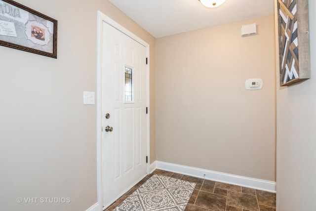 doorway to outside featuring baseboards