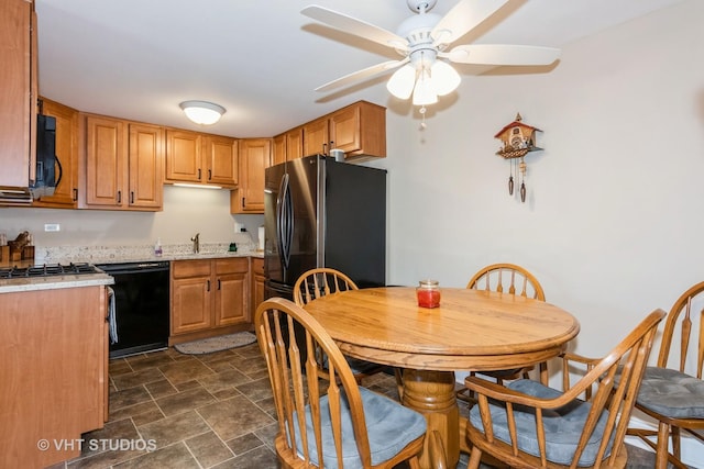 kitchen featuring stone finish floor, a sink, freestanding refrigerator, light countertops, and dishwasher