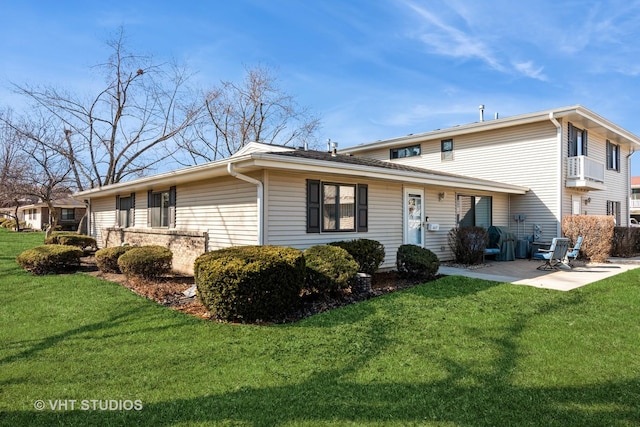 rear view of house featuring a patio and a yard