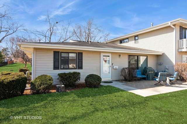 rear view of property featuring a patio and a yard