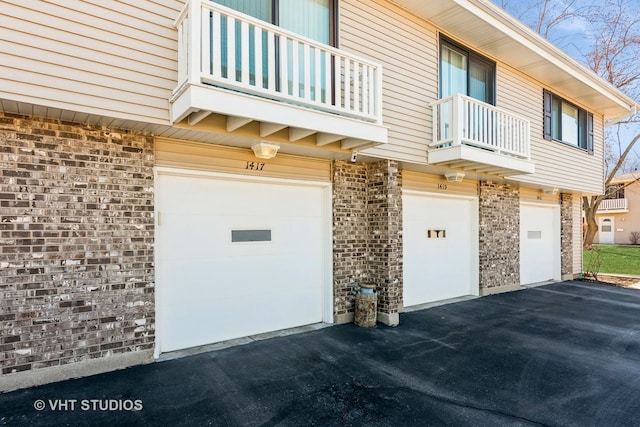 view of property exterior featuring brick siding, driveway, and a garage