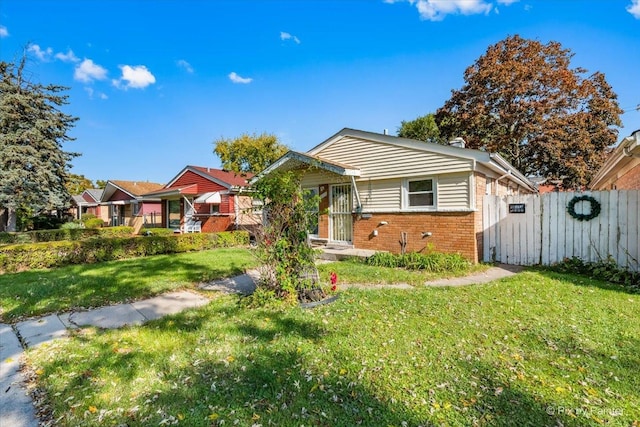 bungalow-style house with brick siding, a front yard, and fence