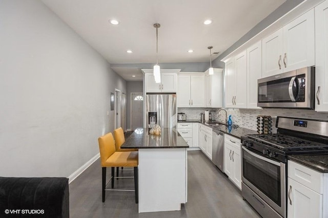 4904 W Fulton St, Chicago, IL 60644 - kitchen with stainless steel appliances, a sink, wood finished floors, backsplash, and a center island