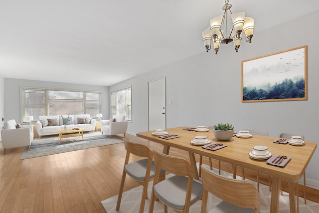 dining space featuring an inviting chandelier, baseboards, and hardwood / wood-style floors