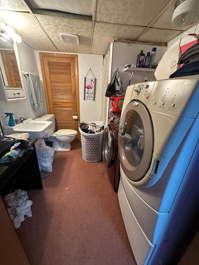 laundry area featuring washer / clothes dryer, visible vents, carpet flooring, a sink, and laundry area