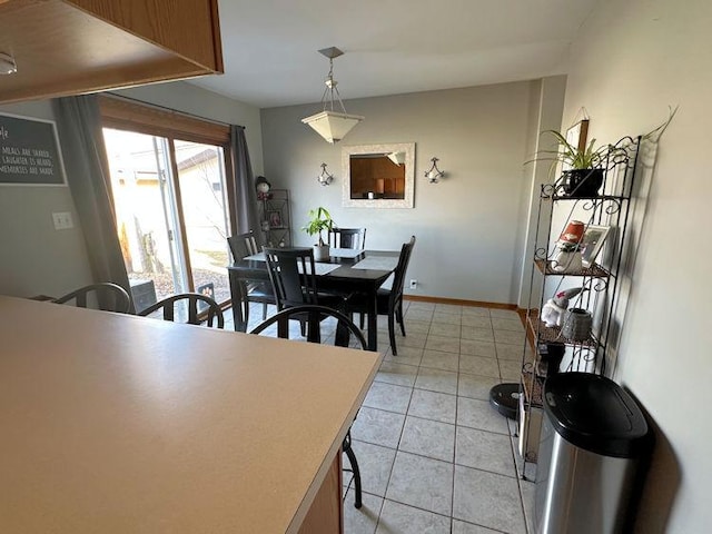 dining space featuring baseboards and light tile patterned flooring