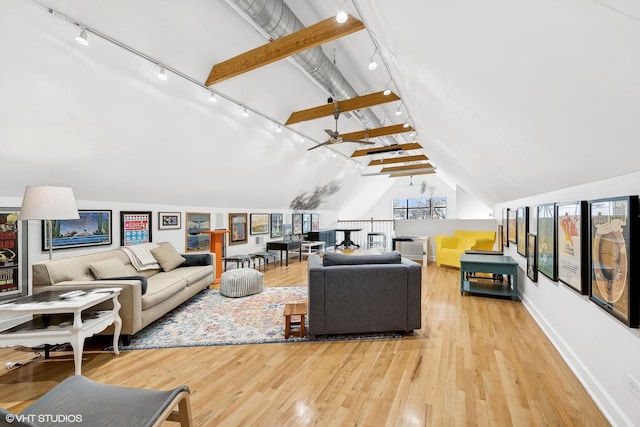 living area with baseboards, rail lighting, vaulted ceiling with beams, and light wood finished floors