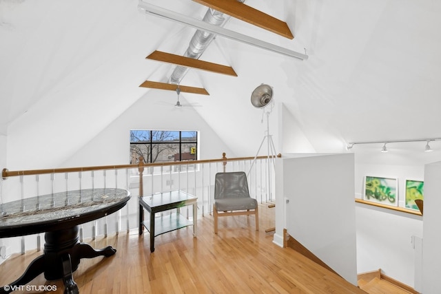 sitting room featuring lofted ceiling with beams, ceiling fan, wood finished floors, an upstairs landing, and track lighting