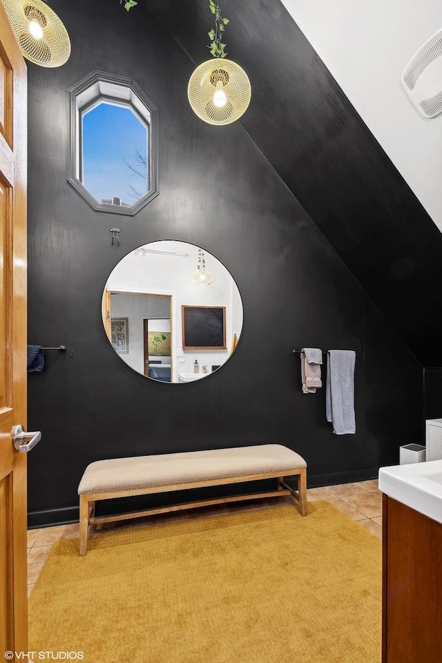 bathroom with lofted ceiling, tile patterned flooring, and visible vents