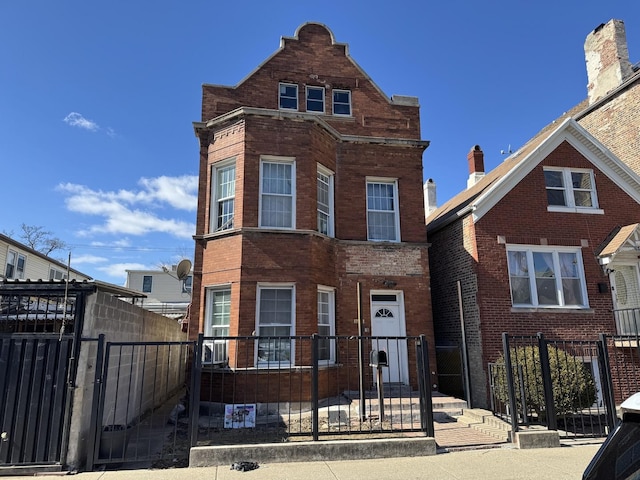 view of front facade featuring a fenced front yard, a gate, and brick siding