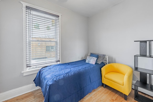 bedroom featuring baseboards, baseboard heating, and hardwood / wood-style floors