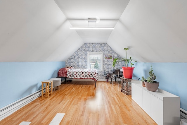 unfurnished bedroom with lofted ceiling, baseboard heating, a baseboard radiator, and wood finished floors