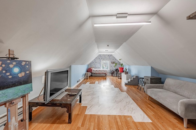 additional living space featuring lofted ceiling and wood finished floors