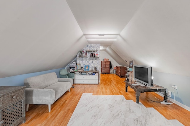 interior space featuring lofted ceiling, baseboards, and wood finished floors