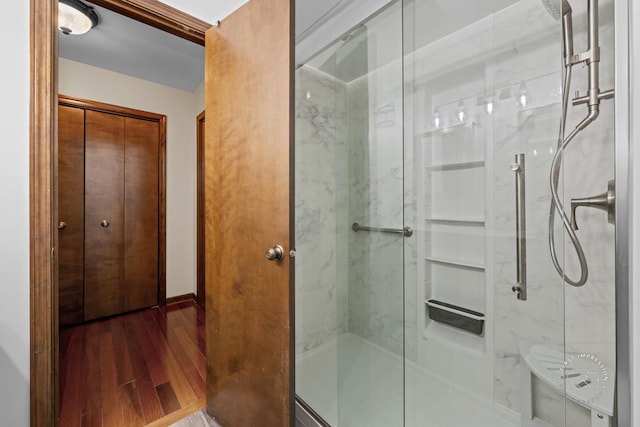 full bathroom featuring wood finished floors and a marble finish shower