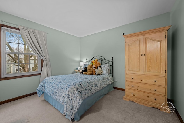 bedroom with baseboards and light colored carpet