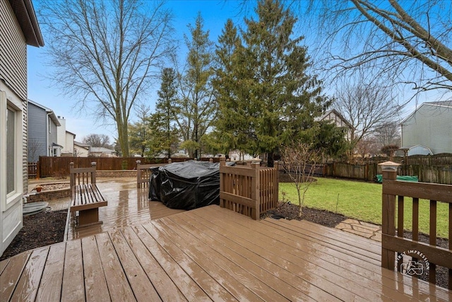 wooden terrace with a fenced backyard and a lawn