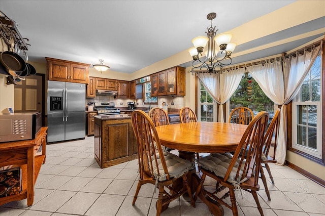 dining room with a healthy amount of sunlight, light tile patterned flooring, and a notable chandelier