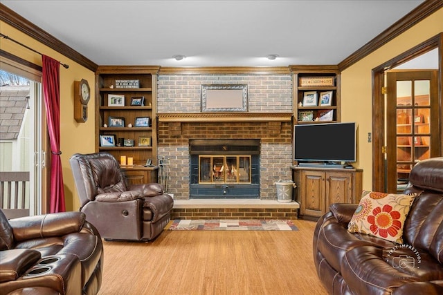 living area with a fireplace, wood finished floors, built in features, and crown molding