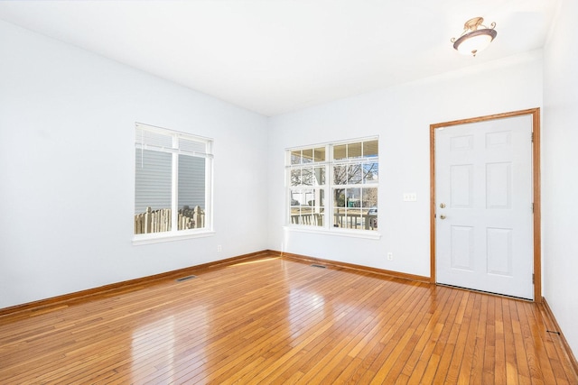 entrance foyer featuring light wood-style floors, visible vents, and baseboards