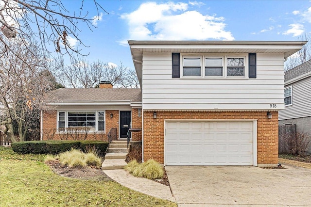 split level home with driveway, brick siding, a chimney, and an attached garage