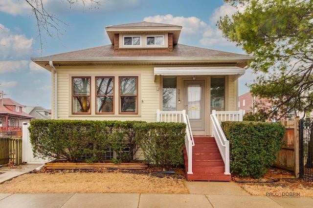 bungalow featuring covered porch and fence