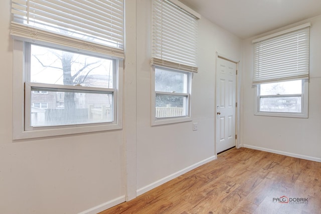 doorway to outside with plenty of natural light, baseboards, and wood finished floors